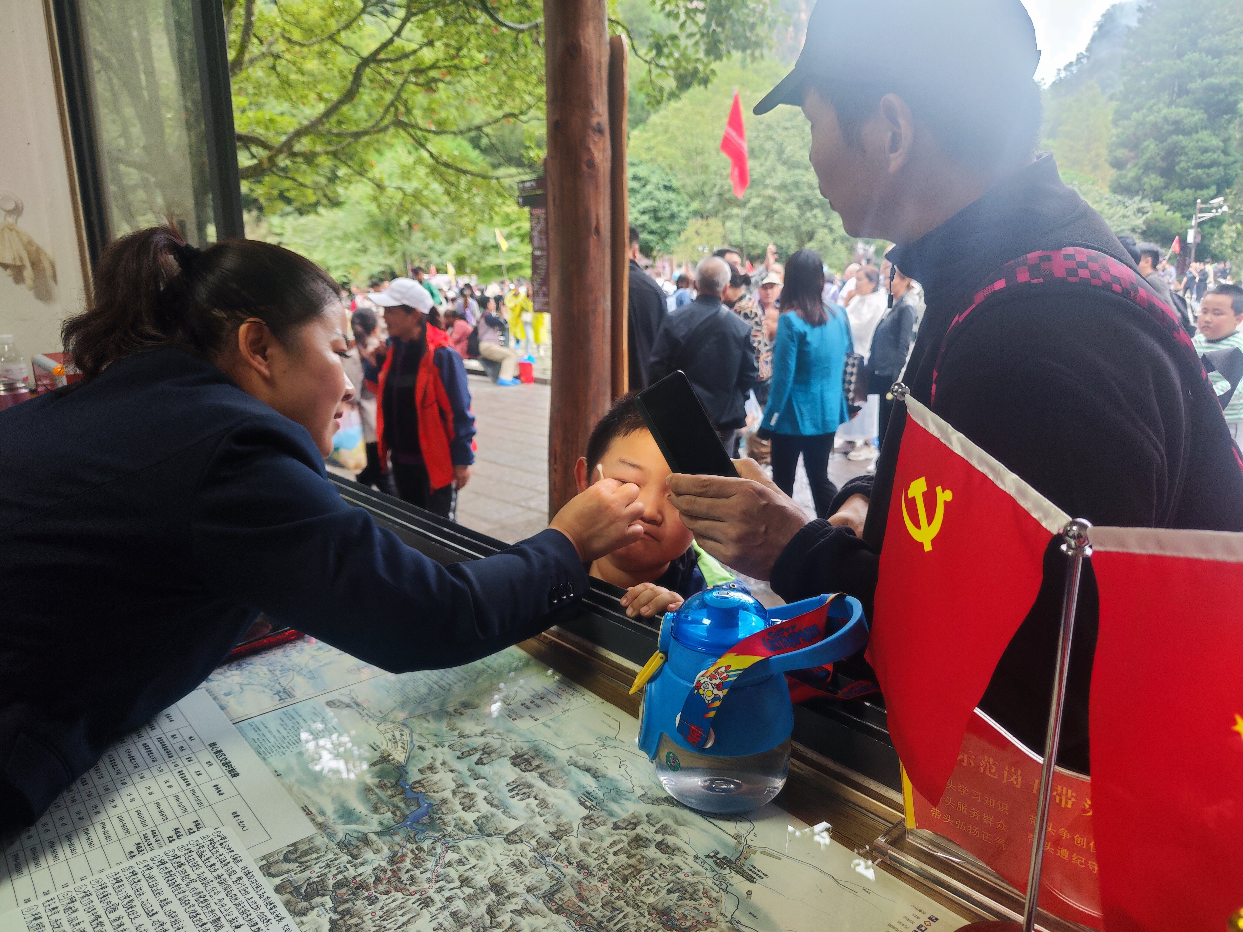 老磨灣黨員義務(wù)咨詢臺(tái)黨員為小游客處理被蜜蜂蟄傷傷口。張娜 攝