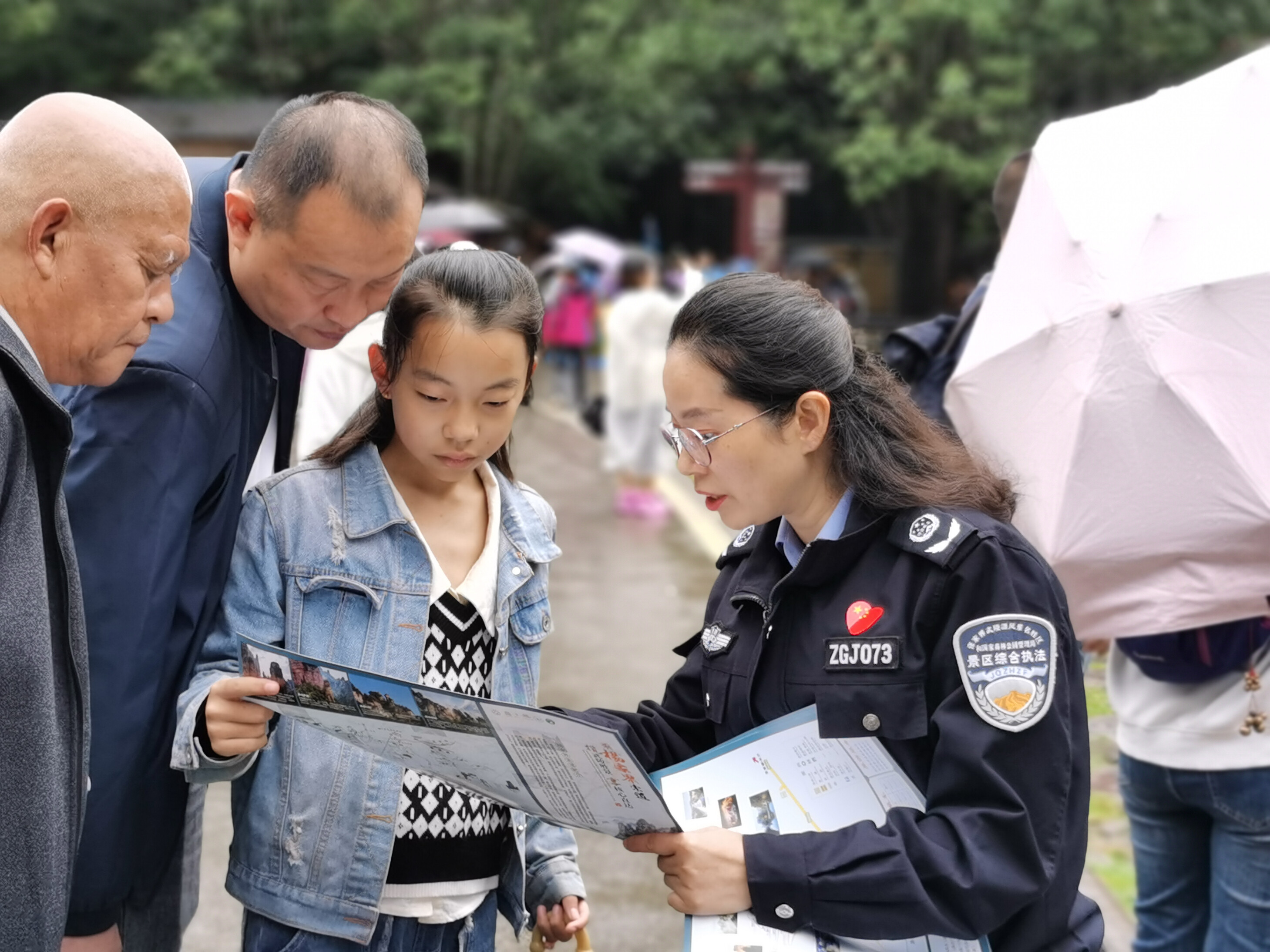 10月1日上年，金鞭溪景區(qū)管委會(huì)女子執(zhí)法隊(duì)隊(duì)員開(kāi)展流動(dòng)導(dǎo)覽服務(wù)，為游客免費(fèi)贈(zèng)送地圖。張娜 攝
